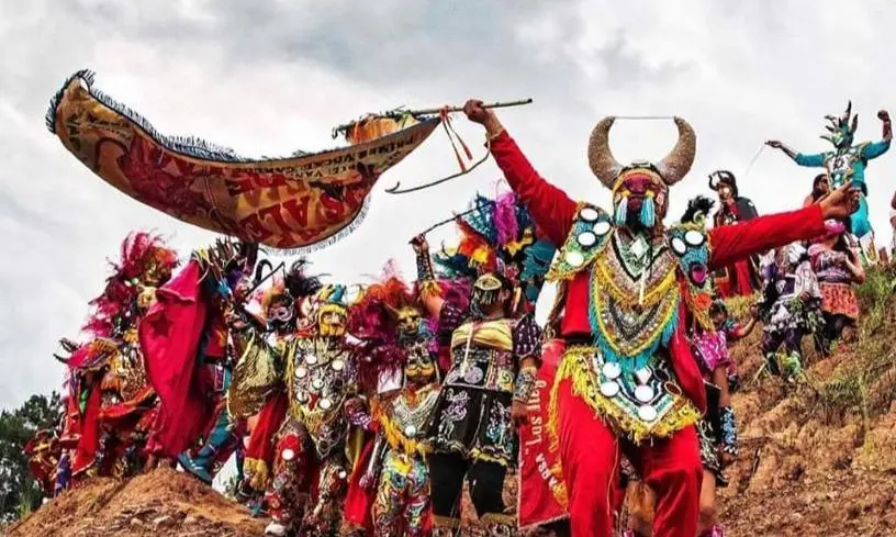 Diablos del Carnaval de Jujuy bailando con trajes coloridos y espejos en la Quebrada de Humahuaca.