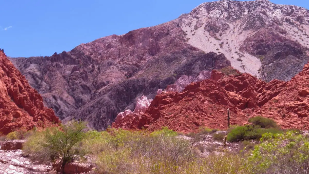 Vista panorámica de los cerros rojos y picos blancos de la Quebrada de las Señoritas en Uquía, Jujuy, ideal para trekking.